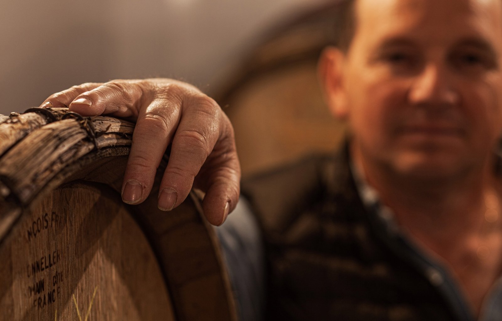 Photographie d'Éric Lagache, vigneron dans sa cave où le champagne repose en fût de bois